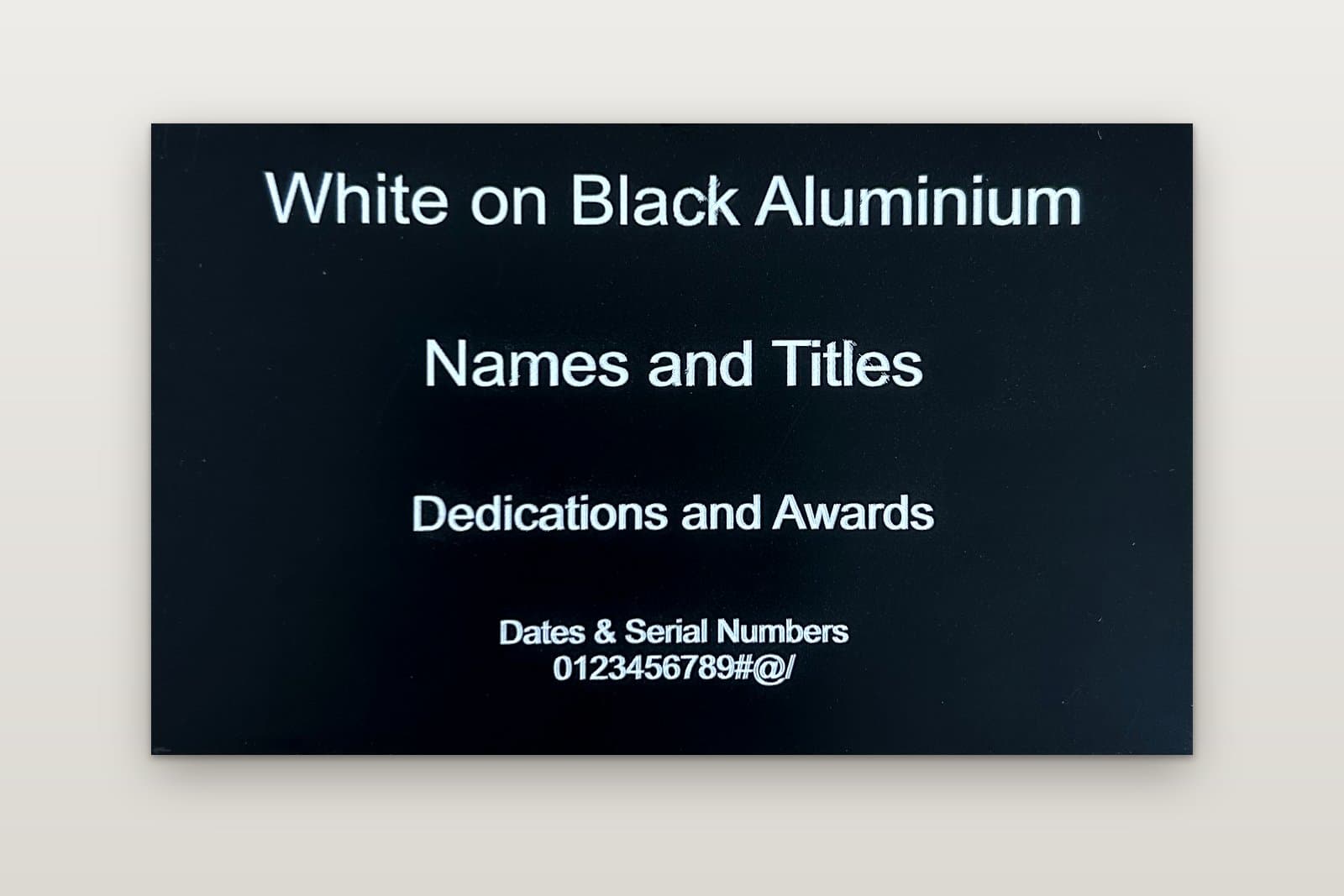 Engraved black anodised aluminium plate with white lettering